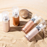 Liquid Highlighter bottles displayed on sandy beach, showcasing Body Luminizer for a luminous glow.